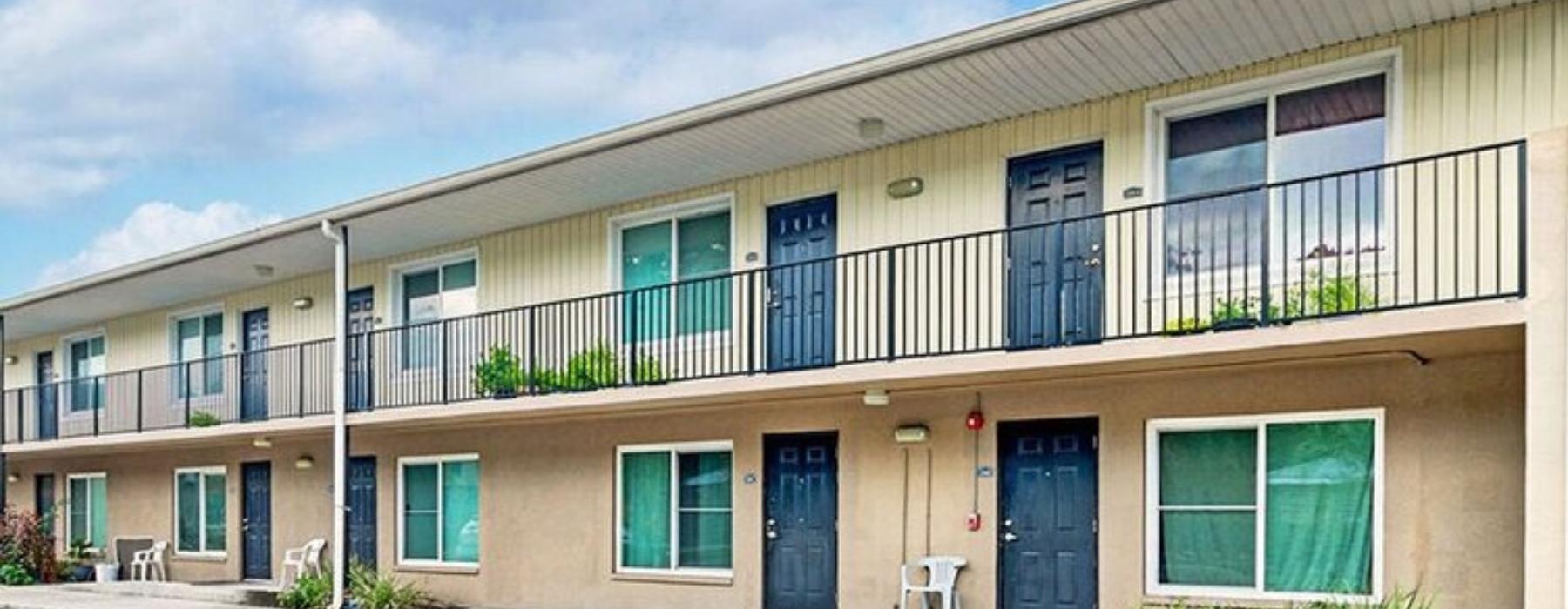 a building with a patio and a patio with chairs and plants